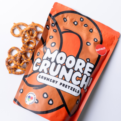 A bag of Moore Crunch Buffalo Regular Size pretzels with some pretzels visible outside the bag.