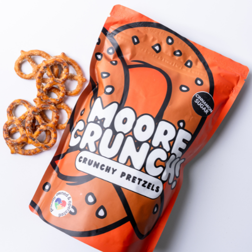 A bag of Moore Crunchy Pretzels with cinnamon sugar flavor. The bag is orange with pretzel images and text.